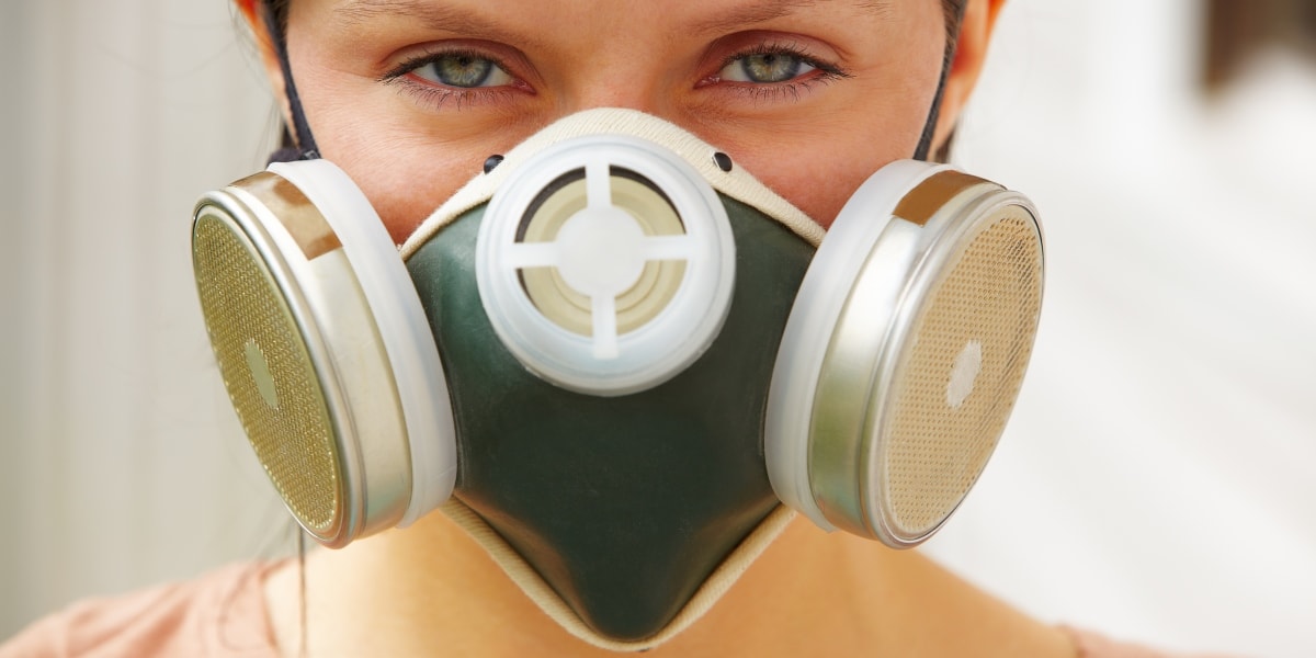 Женщина в защитной маске от грязного воздуха